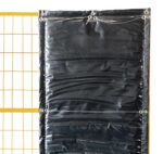 A section of a black sound-absorbing noise barrier securely mounted to a yellow temporary construction fence panel, demonstrating the use of grommets and wire ties for a tight fit.