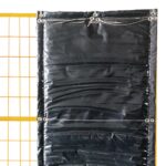 A section of a black sound-absorbing noise barrier securely mounted to a yellow temporary construction fence panel, demonstrating the use of grommets and wire ties for a tight fit.