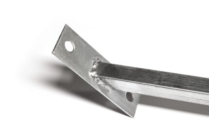 Closer detail view of the angled base plate for a temporary fence windbrace, showing anchoring holes and the welded joint to the square post.