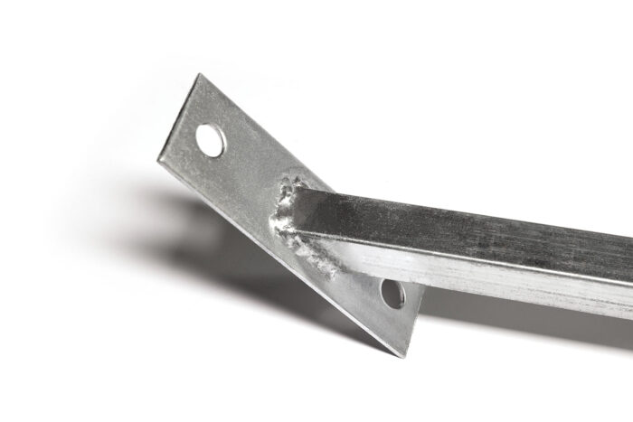 Closer detail view of the angled base plate for a temporary fence windbrace, showing anchoring holes and the welded joint to the square post.