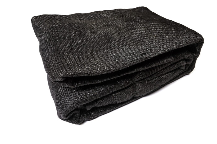 A neatly folded section of heavy-duty black privacy mesh screen, designed to attach to temporary fence panels for wind reduction and site concealment.