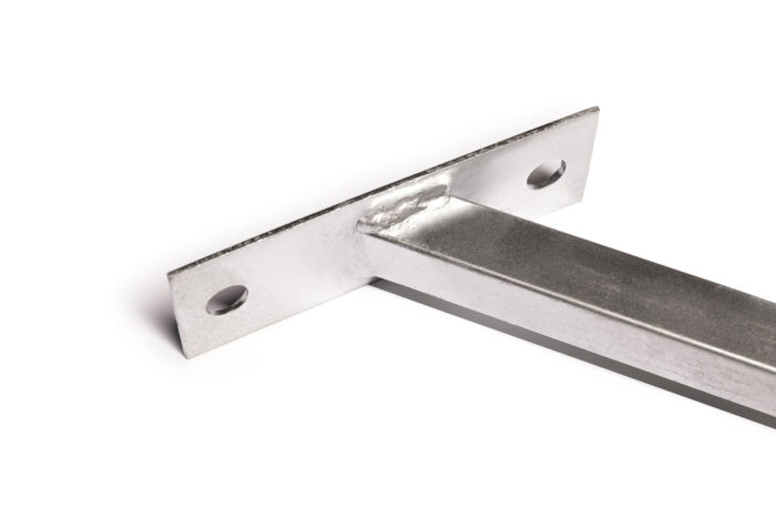 Extreme close-up view focusing on the textured weld seam connecting the vertical slotted tab to the flat galvanized base plate.